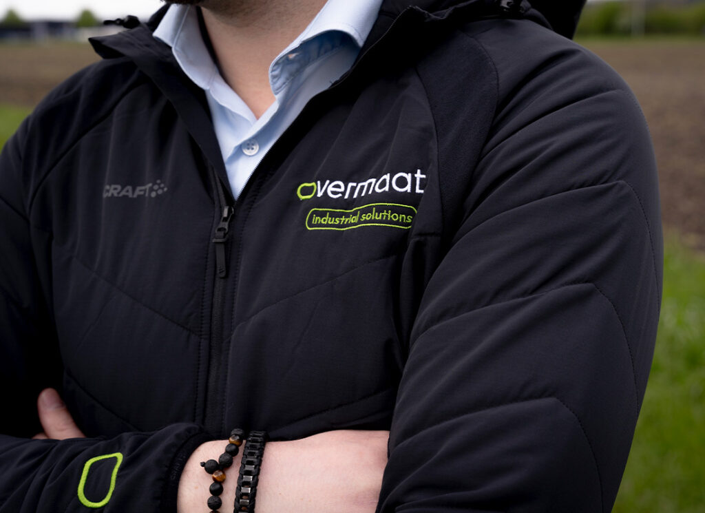 Close-up Overmaat Industrial Solutions logo on shirt